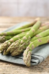 Fresh raw asparagus spears on wooden table, closeup