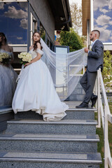Bride and groom take wedding photos at a modern venue on a sunny day