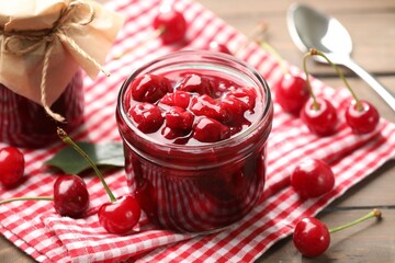 Tasty cherry jam and fresh fruits on wooden table, closeup