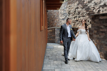 Couple walks hand in hand during outdoor wedding celebration in a charming venue