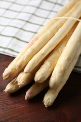 Raw asparagus spears on wooden table, closeup