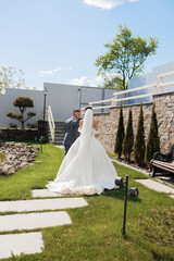 Couple walks hand in hand down a beautiful garden path on their wedding day
