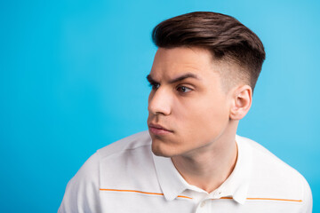 Portrait of a young man in a white polo shirt against a blue background emphasizing stylish...