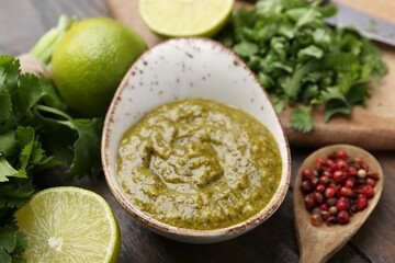 Tasty sauce with cilantro and other ingredients on wooden table, closeup