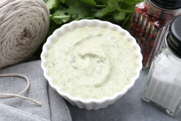 Tasty cilantro sauce in bowl and spices on grey table, closeup
