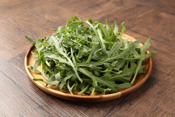 Fresh ripe green arugula leaves on wooden table, closeup