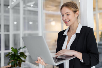 Caucasian good-looking well-dressed woman with a laptop