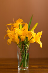 Fresh bouquet of orange lilies on a brown background