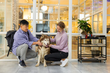 Two colleagues in a coworking area with a dog
