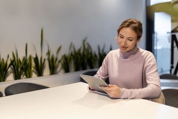 Blonde cute young woman in coworking area feeling good during work