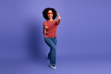 Young woman in casual attire expressing excitement and joy against a vibrant purple backdrop