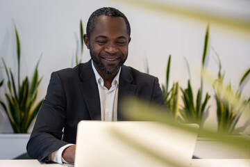Businessman working on a laptop and smiling positively