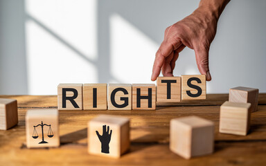 Wooden blocks spelling rights concept with hand arranging letters to symbolize justice and fundamental human rights