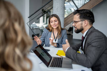 Businesswoman leading meeting with colleagues in modern office