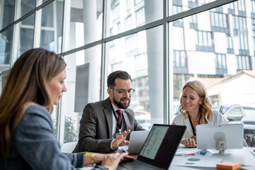 Business people working together on laptops in modern office