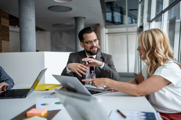 Business people working together on project using laptop in modern office