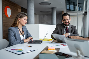 Businesspeople working with laptops during corporate meeting
