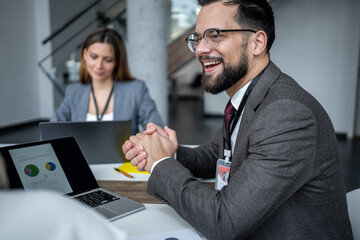 Businessman smiling during corporate meeting at office desk