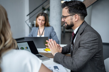 Fototapeta premium Business people having meeting using laptops in office discussing charts