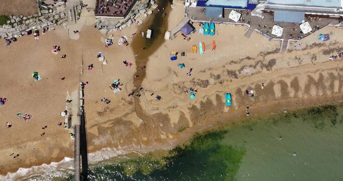 Overhead Drone View Moving from Bar/Beachside Cafe Past a Jetty and Out to the Crystal Clear Sea