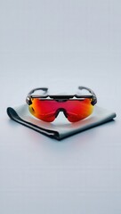 Sporty red tinted sunglasses on microfiber cloth