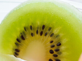 A slice of green kiwi fruit with black seeds
