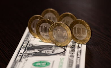 Conceptual story about inflation and the US dollar exchange rate in Kazakhstan with six 100 Kazakhstani tenge coins and a 1 US dollar bill