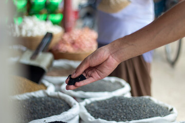 A man holds some Lentils in a sack