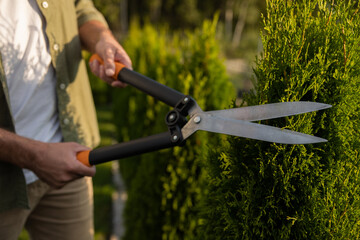 Close up picture of a man with a prune in the garden
