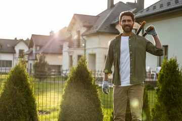 Confident young bearded man wording in the garden and looking resolute