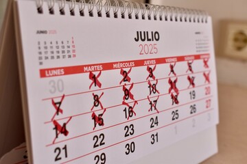 Important dates crossed out in red on Spanish calendar. Concept of waiting, planning, and time...