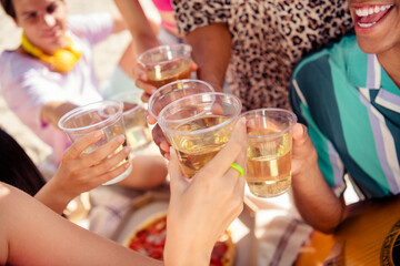 Group of friends toasting with beverages in an outdoor celebration showcasing bonding and joy