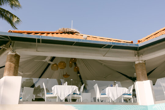 Outdoor dining area at a coastal restaurant offers scenic views and a relaxed atmosphere on a sunny day
