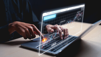 A person interacts with a futuristic holographic data visualization projecting from a laptop, showing graphs and charts in a dimly lit setting.