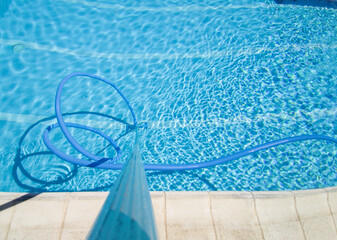 Worker cleaning and vacuuming the bottom of the pool
