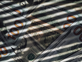 The shadow of the blinds resembles the grid on dollar bills. The concept of prison, punishment for...