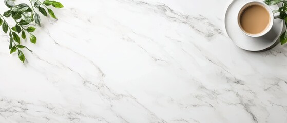 Beverage cup on plate with green leaves placed on white marble surface. Top view arrangement on clean backdrop. Copy space available.