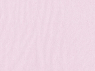 A close-up view of a textured pink paper surface. The paper appears to have a soft, pastel hue with subtle variations in color, contributing to a slightly uneven texture. 
