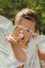 Happy little baby girl playing in a sunny park. Childhood joy, Mother's Day, outdoor activity,...