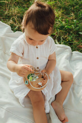 Happy little baby girl playing in a sunny park. Childhood joy, Mother's Day, outdoor activity,...