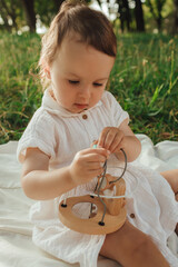 Happy little baby girl playing in a sunny park. Childhood joy, Mother's Day, outdoor activity,...