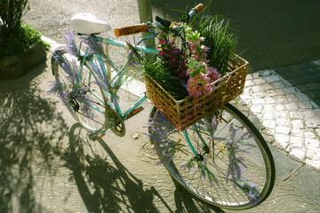 A charming mint-green bicycle decorated with artificial lavender and a basket full of vivid flowers...