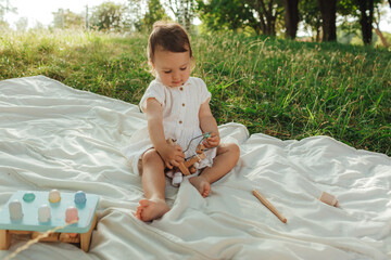 Happy little baby girl playing in a sunny park. Childhood joy, Mother's Day, outdoor activity,...