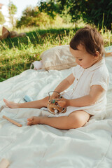 Happy little baby girl playing in a sunny park. Childhood joy, Mother's Day, outdoor activity,...