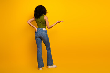 Young woman posing against a vibrant yellow background in trendy casual attire, showcasing...