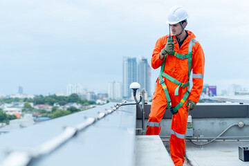 Professional technician worker or engineer use walkie-talkie to discuss with co-worker near solar cell panel during check or maintenance in area of factory or rooftop building.