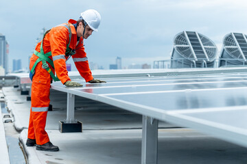 Technician or factory worker man bend body and look to  maintenance rooftop solar cell system with cloudy sky.