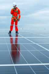 Vertical image with main focus on solar cell panel with technician worker or professional engineer...