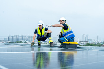 Two engineer or technician worker discuss together during work with solar cell panel on rooftop of...
