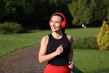 Sporty woman with headphones running in park